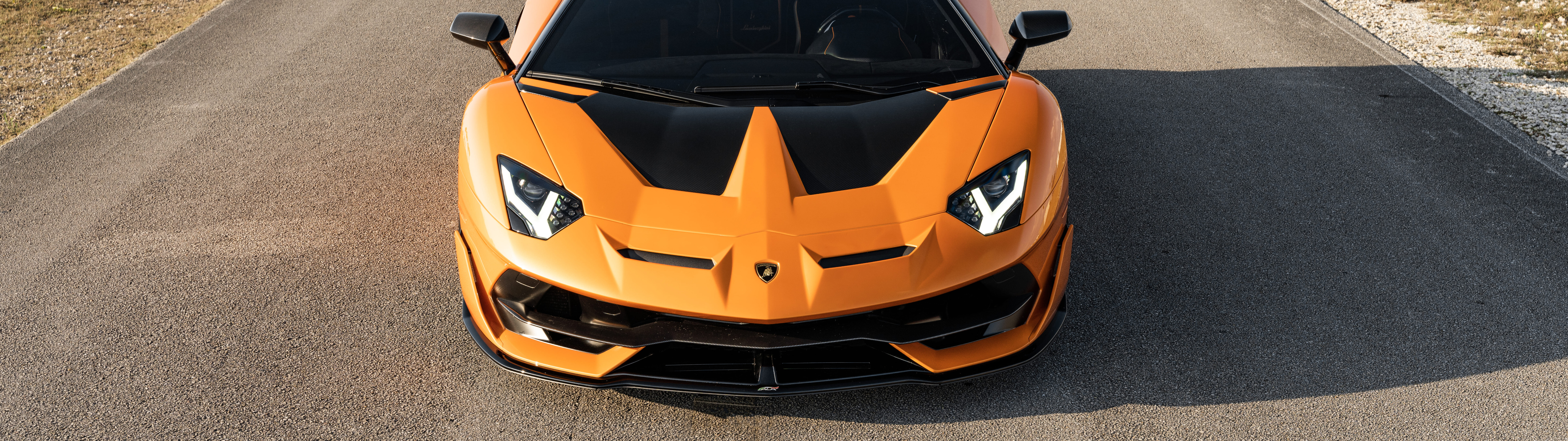 Lamborghini Aventador SVJ'nin yakından çekilmiş bir görüntüsü; şık aerodinamik gövdesi ve etkileyici süperspor otomobil silueti ön planda.