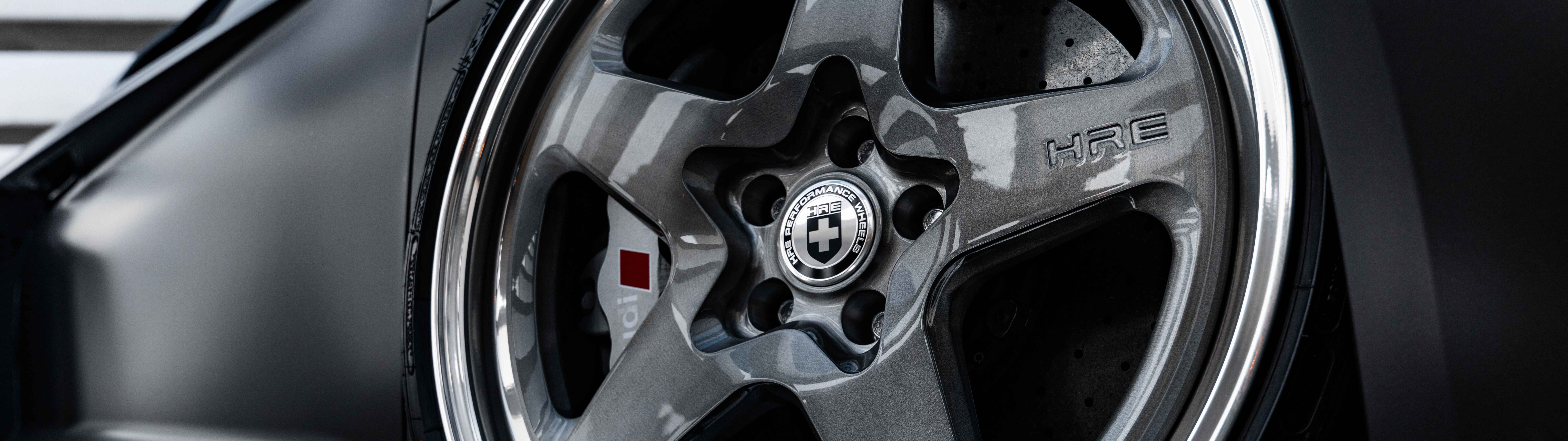 Şık bir Audi lüks sedanın, kusursuz bir şekilde parlatılmış metalik yüzeyini vurgulayan, profesyonelce çekilmiş yakın plan bir fotoğraf.