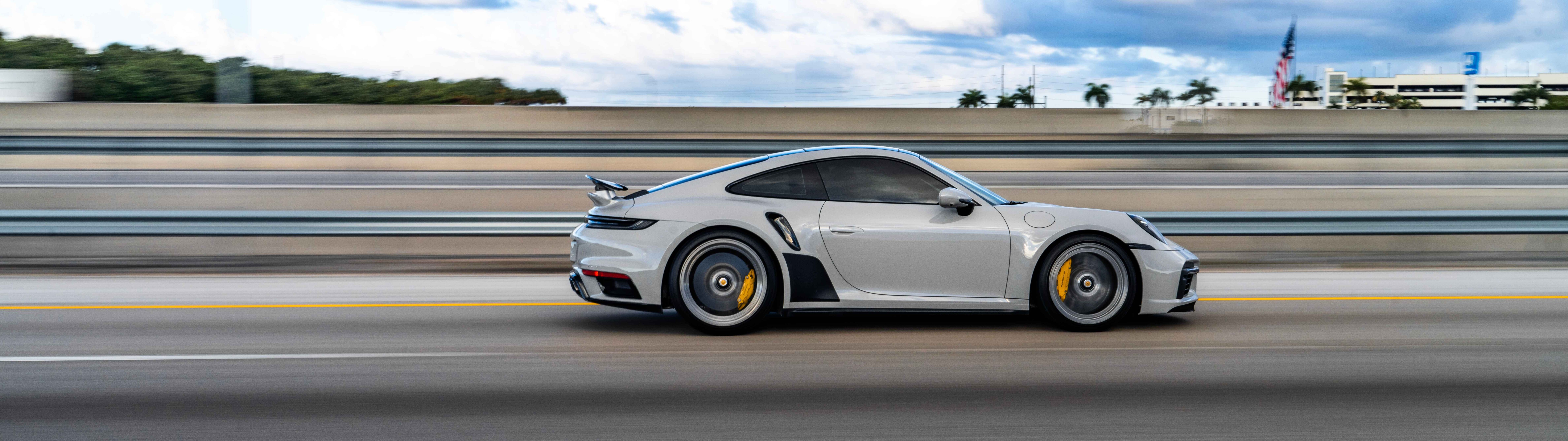 Şık tasarımı ve metalik görünümüyle dikkat çeken, lüks bir Porsche spor otomobilin yakın çekim görüntüsü.