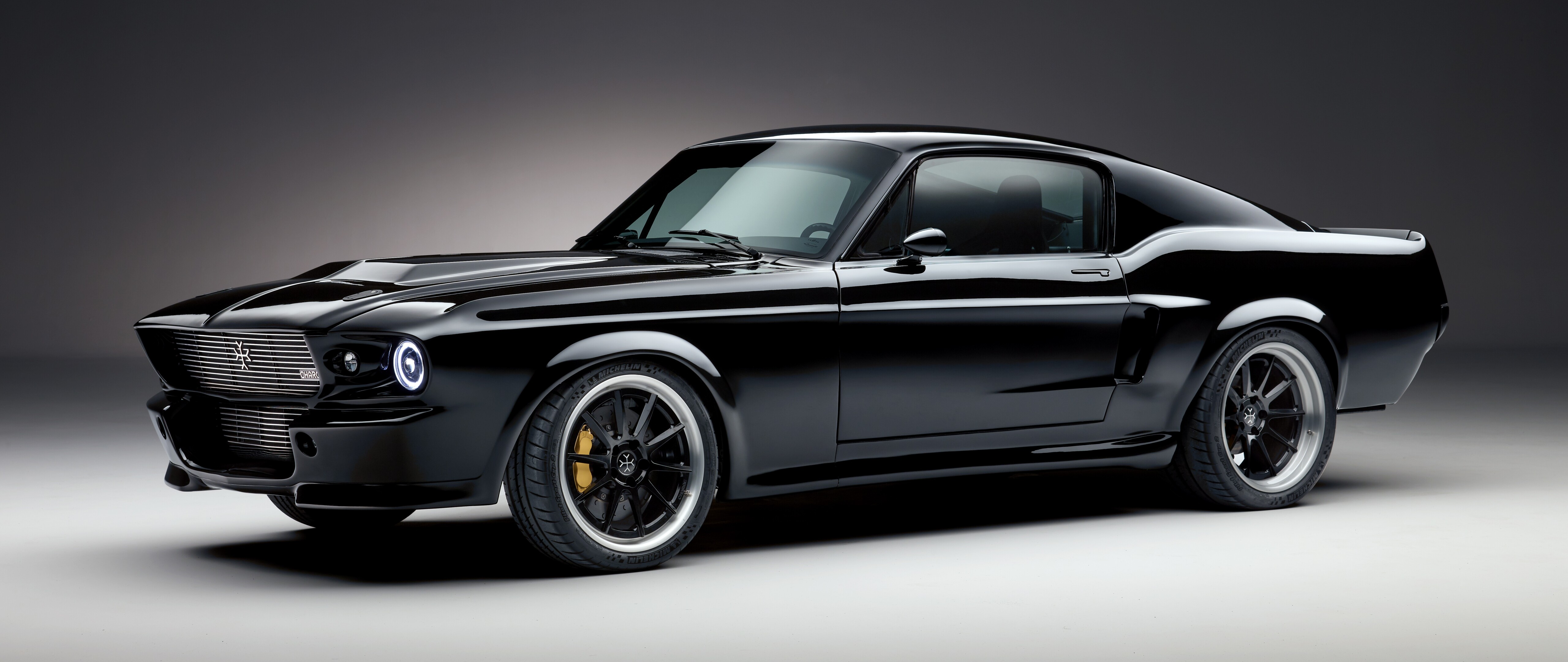 Şık ve agresif bir tasarıma sahip, modern, siyah renkli, elektrikli bir Ford Mustang kas arabası.