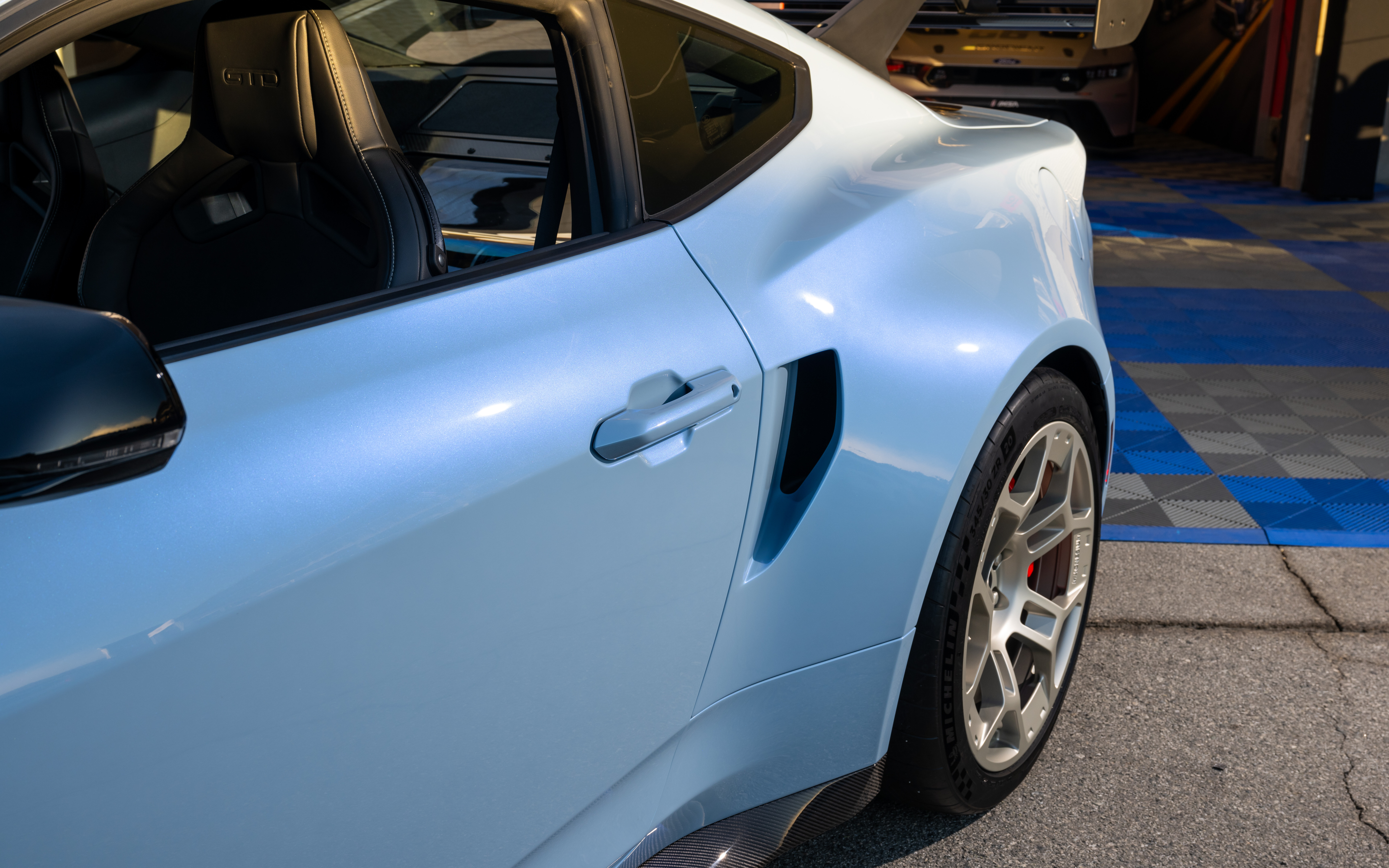 Agresif aerodinamik tasarımı ve geniş gövde kitiyle dikkat çeken bir Ford Mustang GTD'nin detaylı görünümü.